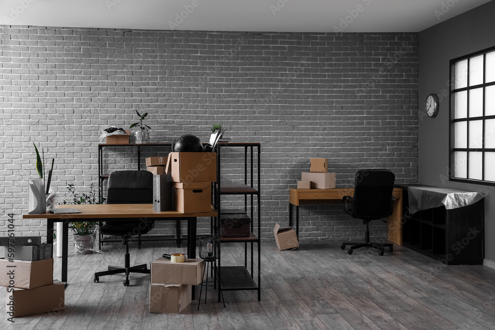 Workplaces with cardboard boxes in office on moving day