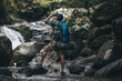 © Charnchai saeheng - Hikers standing on the rock and use binocular to see animals and view landscape with backpacks and waterfall background in the forest. hiking and adventure concept.