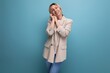 © Ivan Traimak - cheerful blonde young woman in jacket on studio background with copy space