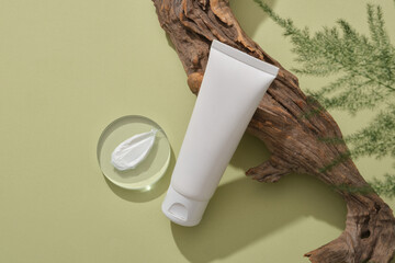 Sticker - Cosmetic container without label is leaning on a big tree branch, a round transparent with cream texture and leaves arranged. Beauty product mockup