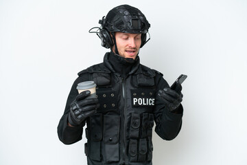 SWAT man over isolated white background holding coffee to take away and a mobile