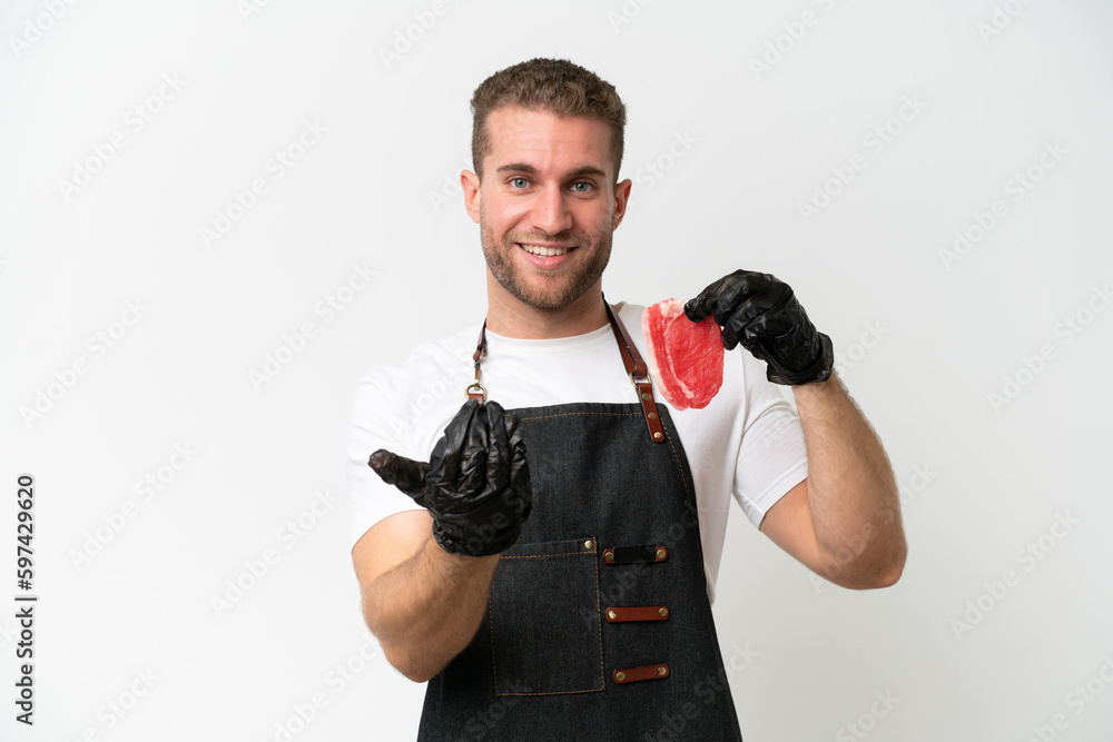 Butcher caucasian man wearing an apron and serving fresh cut meat isolated on white background inviting to come with hand. Happy that you came