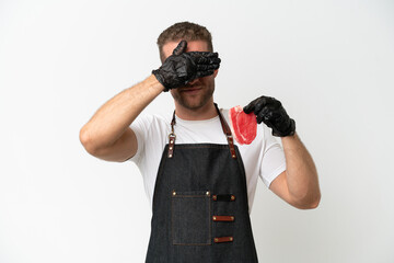 Wall Mural - Butcher caucasian man wearing an apron and serving fresh cut meat isolated on white background covering eyes by hands. Do not want to see something