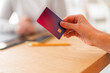 © Studio Marmellata - Crop anonymous female hand holding a credit card, out of focus background