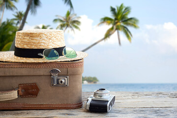 travel concept suitcase and hat on wooden table