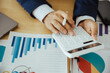 © Witoon - Close up of business analysis, investment and finance concept. Businessman, accountant calculating business report. market information Financial graph while working on laptop computer with spreadsheet
