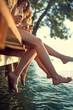 © luckybusiness - Happy friends enjoying together at holiday and dangling legs in the water