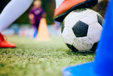 Fototapeta Sport - Close up of soccer player with ball during practice on playing field.