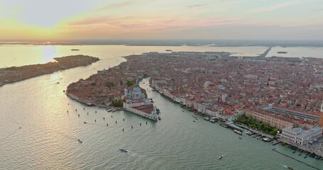 Wall Mural - Aerial Sunset or Sunrise Shot of Central Venice city skyline, Italy. Panorama drone footage of famous tourist attraction from above. Basilica di Santa Maria della Salute, Grand Canal and lagoon. 