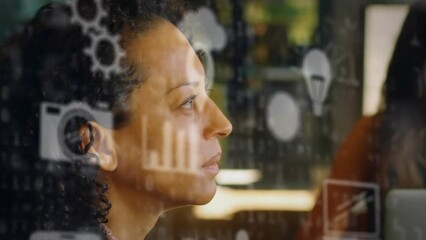 Canvas Print - Animation of multiple icons over binary codes against thoughtful biracial woman at office