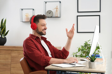 Poster - Man in headphones studying on computer at home. Online translation course