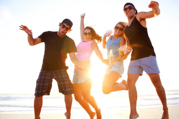 Friends, jump and beach portrait in sunset with freedom, youth and happiness on vacation together. Excited men, women and smile outdoor by ocean, sunshine and waves in summer, holiday and happy group