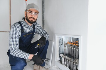 Wall Mural - Young engineer adjusting autonomous heating