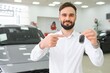 © Serhii - Yes, that's my new car. Customer in car dealership. Young man with keys in hand