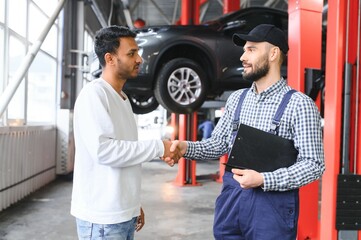 Wall Mural - A mechanic in a car service is talking to an Indian car owner. Car service concept.