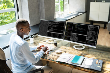 African American Coder Using Computer At Desk