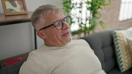 Poster - Middle age grey-haired man relaxed on sofa breathing at home