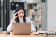© kenchiro168 - The stressed and exhausted millennial Asian businesswoman is seen sitting at her office desk with her hand on her head, indicating a hard working day where she is overloaded with work.