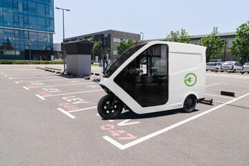 Sticker - Electric tricycle scooter with charging station on a parking lot for LEV - light electric vehicles	