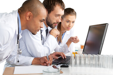 Wall Mural - Portrait of Doctors Looking at Laptop and Writing on Clipboard