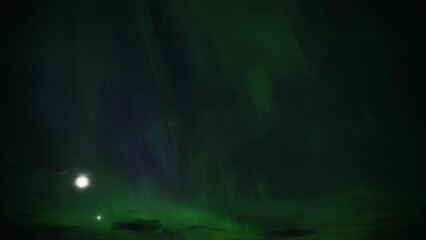 Wall Mural - Aurora Borealis lighting up the night sky next to the Moon and Venus. Timelapse. 