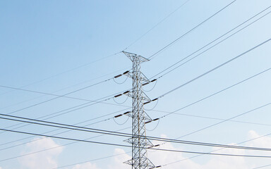 High voltage post or transmission towers in nature day light. Huge source of electric power. High-voltage tower. Electricity is basic of each country. Bright blue sky with bright sunlight background.