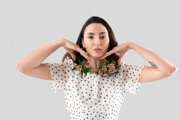 Sticker - Young woman in dress with alstroemeria flowers on grey background