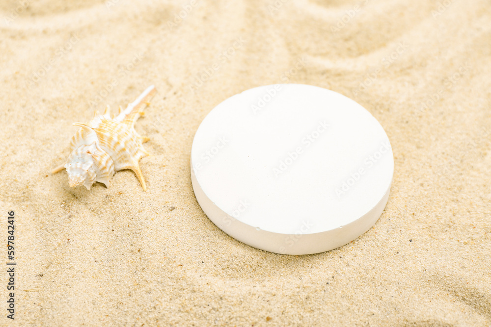 Decorative plaster podium and seashell in sand