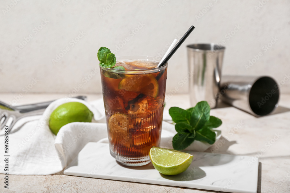 Glass of tasty Cuba Libre cocktail on light background