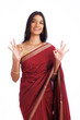 Cheerful Indian woman in traditional saree showing ok sign isolated on white.