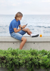 Wall Mural - young man walking along the promenade and taking pictures