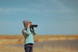 © nicoletaionescu - Little Girl using a Binocular Checking Nature Outdoors. Curious child observing scenery using a pair of binoculars