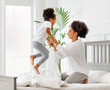 © JenkoAtaman - Happy ethnic family. African american kid jumping, play and laugh on bed with mom.