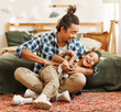 © JenkoAtaman - Happy afro american family father and son laughing and playing while sitting on bed at home.