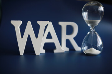 WAR, word written in wooden alphabet letters on blue background. The concept of a terrible war destroying country.