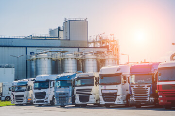 Cargo trucks along the road at the blue sky background 