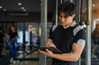 © Surachai - young man in sportswear Checking equipment in gym, fitness, sport, exercise concept