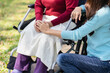 Family relationship Asian senior woman in wheelchair with happy daughter holding caregiver for a hand while spending time together