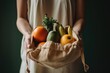 Hands holding a reusable grocery bag filled with healthy food items like fruits and vegetables.
