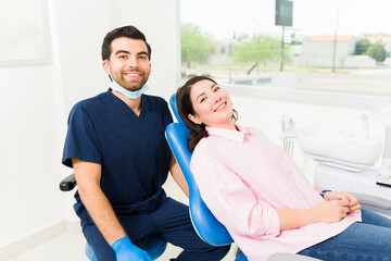 Wall Mural - Attractive dentist and beautiful woman patient making eye contact