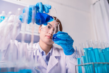 Wall Mural - chemist,scientist hand holding pour the substance from experimental bottle into flask , science rese