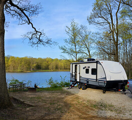 travel trailer camping in the forest by the lake at moraine view state park, illinois