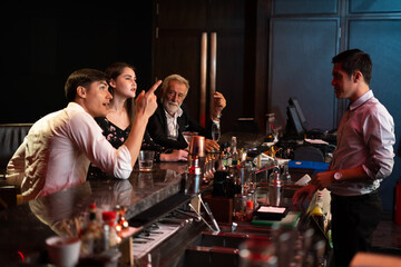 Wall Mural - Peoples having fun watching football game on TV and drinking beverages at bar counter in nightclub