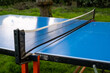 Ping pong table on green grass. Folding table for playing small tennis. Active leisure.