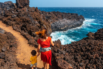 Wall Mural - A family on the volcanic trail in the village of Tamaduste on the coast of the island of El Hierro, Canary Islands, Spain