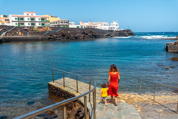 Wall Mural - A mother and her son in the seaside tourist village Tamaduste on the island of El Hierro, Canary Islands, Spain