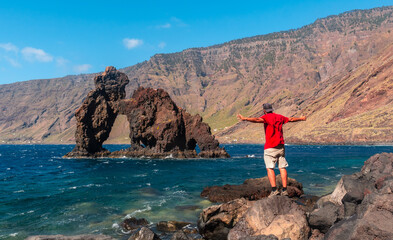 Wall Mural - A young man in the touristic icon of El Hierro island called El Roque de la Bonanza, Canary Islands, Spain