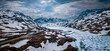Snowy landscape of Hardangervidda national park with mountains and a road along icy lakes in Norway, from above