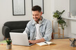 © New Africa - Online translation course. Man typing on laptop at home