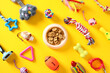 © photoguns - Flat lay composition with pet training accessories and bowl of dry food on yellow background. Pet care concept.